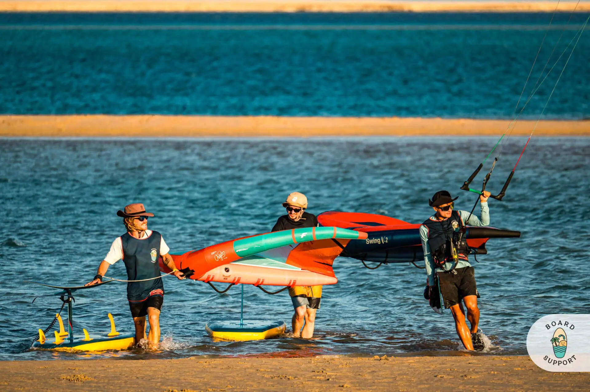 Grupa kitesurferów niesie sprzęt na brzeg po zakończonej sesji w Dakhla