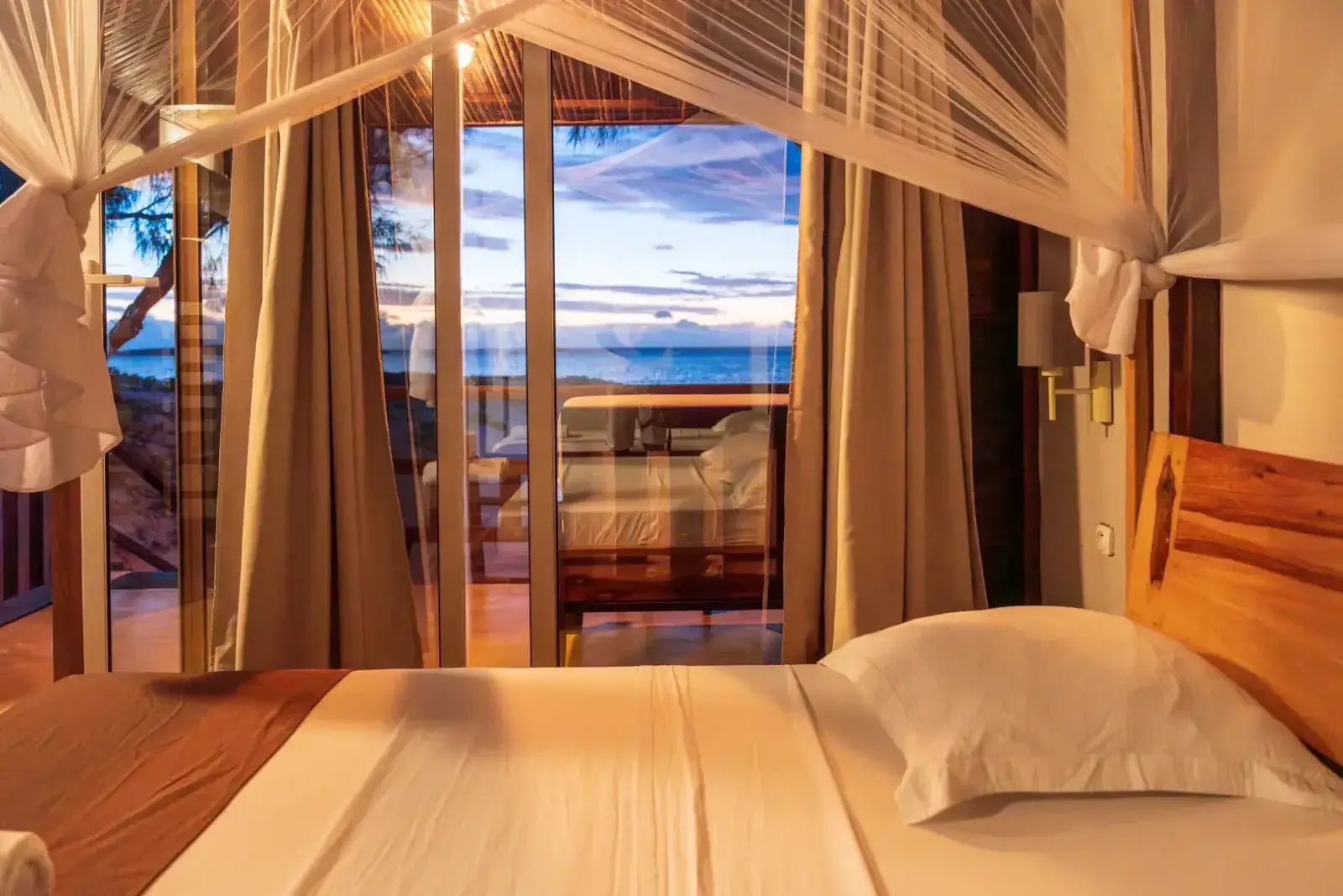 Łóżko i moskitiera w bungalowie przy plaży, Madagaskar